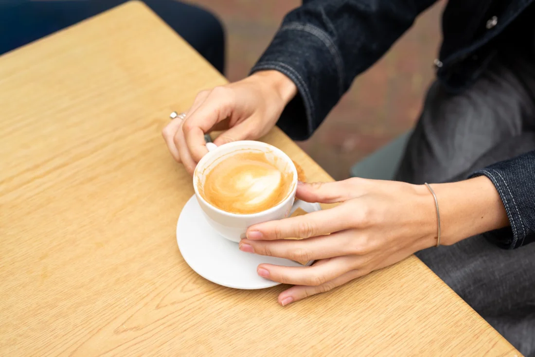 Een kop koffie aan tafel tijdens een gesprek